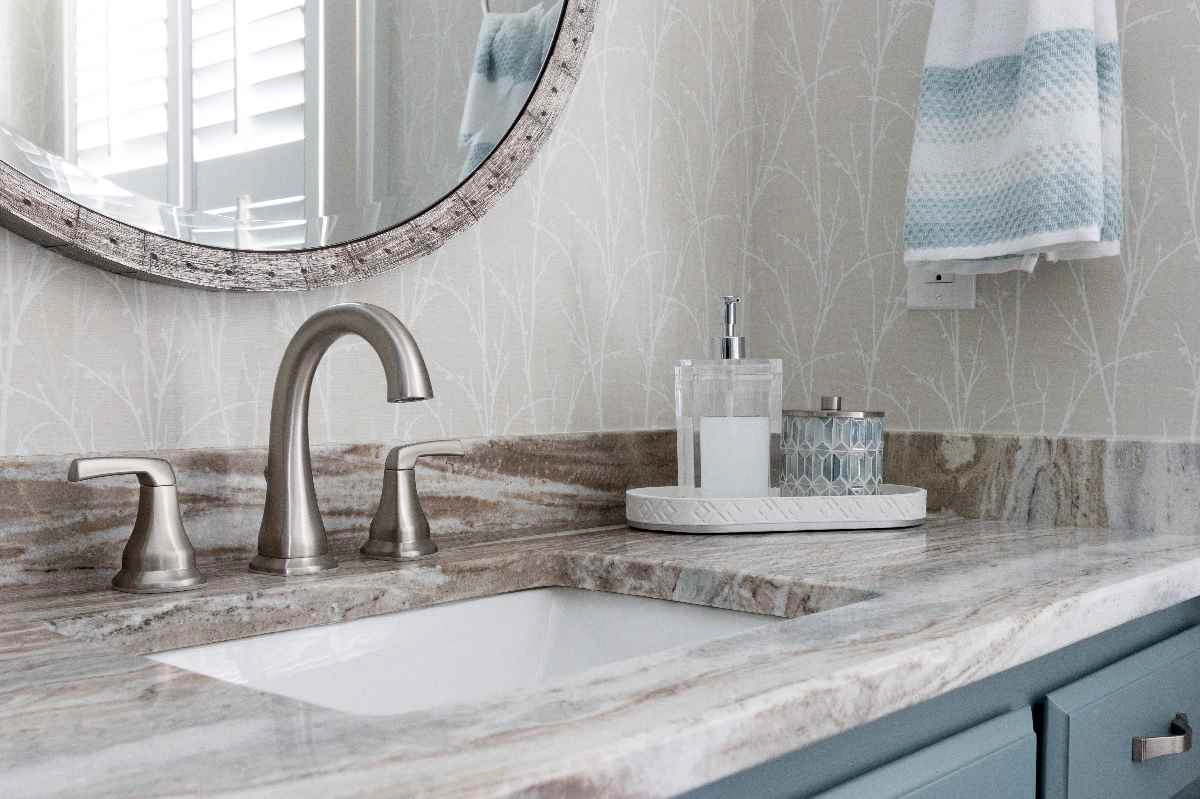 A tan counter tops blue-painted cabinets for a fresh, updated look in a secondary bath.